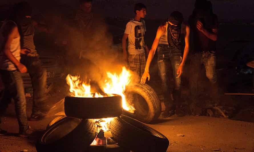 Teenagers from al-Am’ari refugee camp in Ramallah burn tyres during clashes with Israeli troops at the Qalandia checkpoint