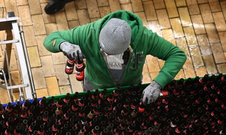 A person seen from above as they sort bottles on a production line