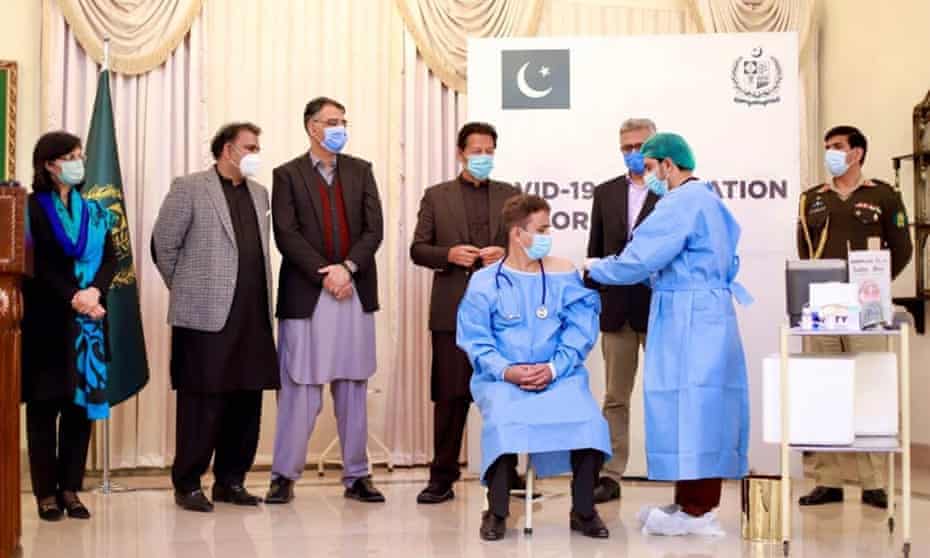 Pakistan’s prime minister Imran Khan, back row, third from right, watches as Chinese vaccine is administered to health workers last month.