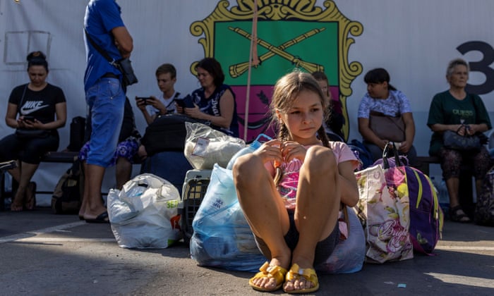 Anastasija Maksimova rests as she waits with her family to be transferred to other parts of the country, in Zaporizhzhia.