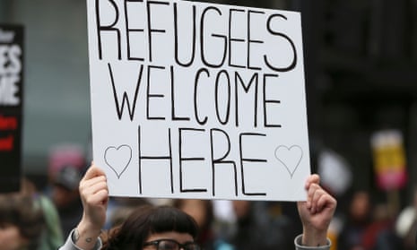 A protester holding a 'Refugees Welcome' sign