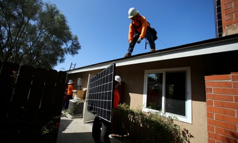 Workers lift a solar panel on to the roof of a house in San Diego, California, US. 