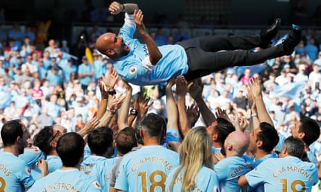 Manchester City manager Pep Guardiola and their players and staff celebrate winning the league.
