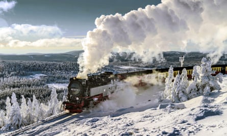 A steam train on the Harz railway, travelling through snowy countryside.