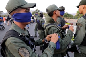 Armed soldiers wear blue bands while standing guard near the Generalissimo Francisco de Miranda airbase. Juan Guaidó appeared wearing a similar band in a video with a contingent of heavily armed soldiers