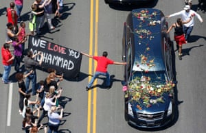 A well-wisher holding a banner touches the hearse carrying the remains of Muhammad Ali