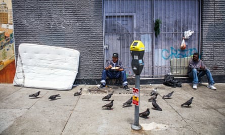 Felix Estrada Garcia (left), a homeless man, eats his lunch on the sidewalk in the Tenderloin district of San Francisco, California.