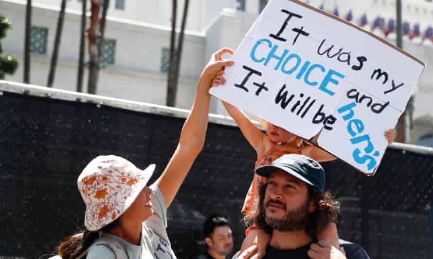 During a rally outside the City Hall of Los Angeles, people are holding up a sign that says, 