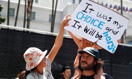 People hold up a sign reading ‘It was my choice and it will be hers’ during a rally outside city hall in Los Angeles.