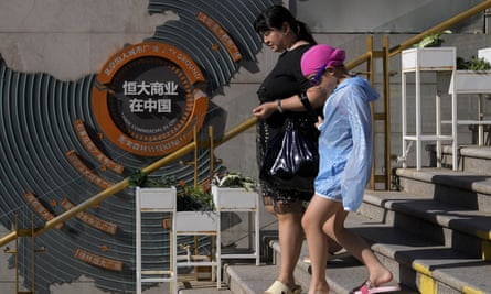 People walk by a map in Beijing showing Evergrande development projects in China.