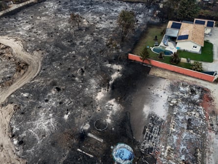 A drone view shows a burnt-out house with a pool