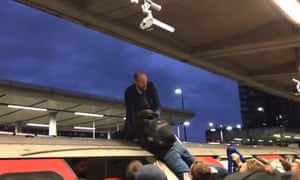 A furious commuter drags an Extinction Rebellion protester off the roof of a Tube train at Canning Town last week.
