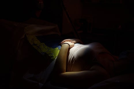 a pregnant teenager lies down while waiting for an abortion