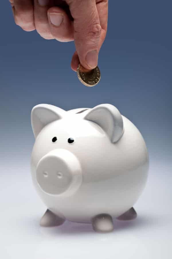 Piggy bank with fingers putting a coin in