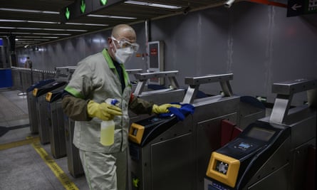 A Chinese worker wears a protective mask and goggles as he cleans and disinfects machines at a nearly empty subway station during rush hour in Beijing.