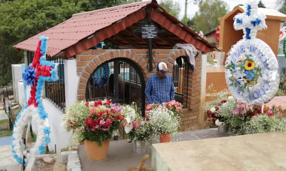 A man stands next to the grave of Raúl Hernández, a tour guide working at a famous butterfly reserve in the western state of Michoacán whose body was found on Saturday, at a cemetery in Angangueo, Mexico.