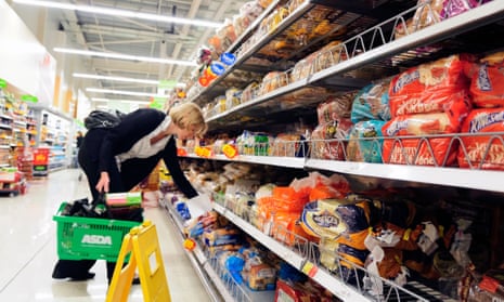 Woman buying bread in an Asda supermarket, England, UK