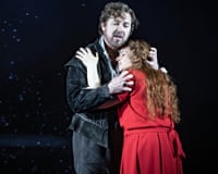 A woman in a red dress embraces a bearded man.