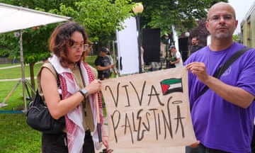 Two demonstrators hold up a sign that says, "Viva Palestina"