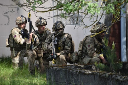 Soldiers geared up outside a building.