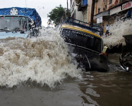 A car and a truck float along a flooded street