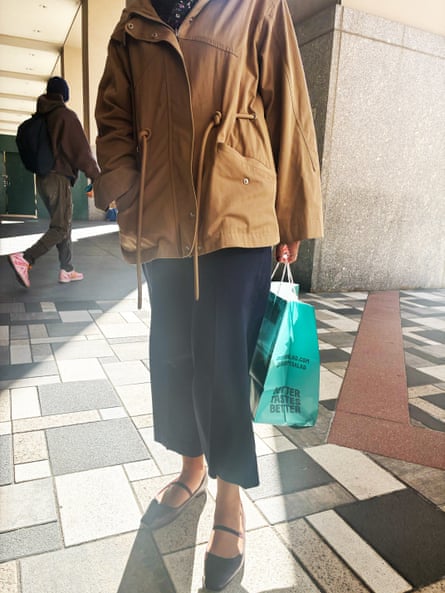 a woman in a tan jacket