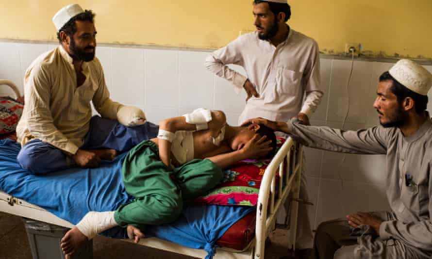 Male relatives comfort 12-year-old Bilal as he breaks down in tears in a Jalalabad Hospital bed beside his uncle Zarghun Shah, left, two days after they survived a US drone strike that killed their father and brother respectively.