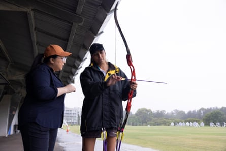Archery instructor Virasha runs Jennifer Wong through the basics