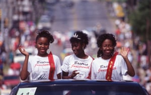 Teen girls wave to a crowd as they ride in an annual Juneteenth parade in Austin, Texas, in 1990