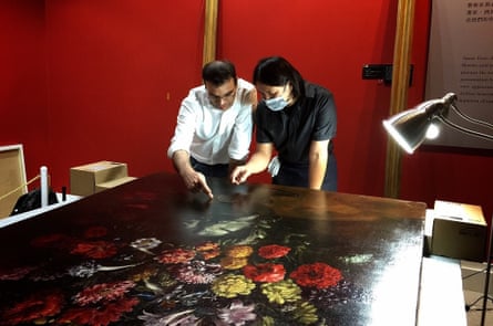 Museum staff and chief conservator Tsai Shun reviewing the damage to the painting in Taipei.