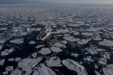 A research ship moves through ice floes