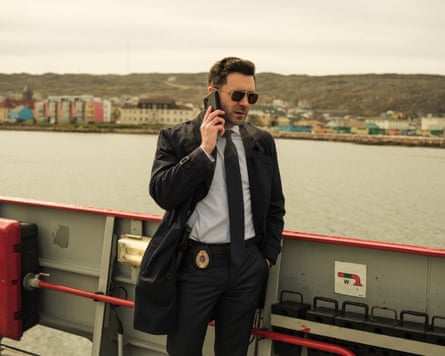 He stands on the deck of a ferry, talking into his mobile phone