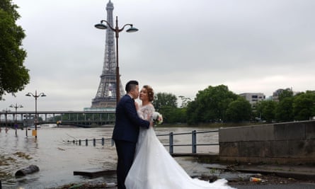 A Chinese couple pose for a wedding photograph on the flooded banks of the Seine.