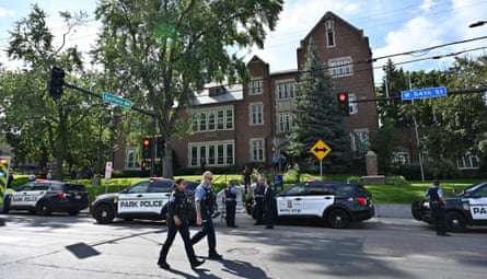 Police and first responders on the street outside a redbrick three-storey school building