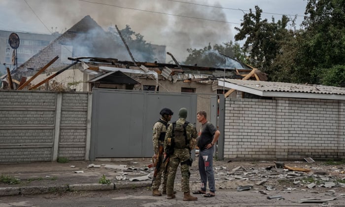 Police officers speak with a local resident as his house burns following shelling, as Russia’s attack on Ukraine continues, in Lysychansk, Luhansk region Ukraine June 2, 2022.