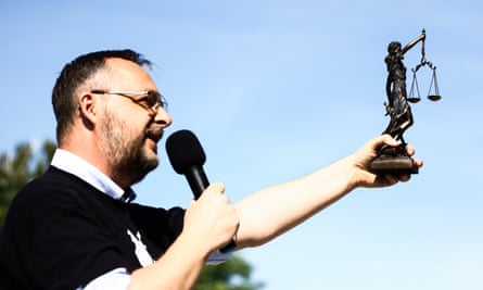 Judge Mariusz Czajka holding microphone and statue