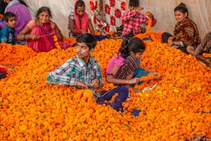 People prepare marigold garlands for Diwali at a wholesale market in Ghazipur, Delhi
