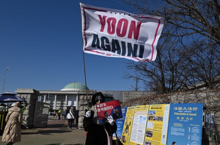 A supporter of South Korea’s ousted president Yoon Suk Yeol wave a flag reading “Yoon, Again!” during a rally marking the first anniversary of Yoon’s declaration of martial law.