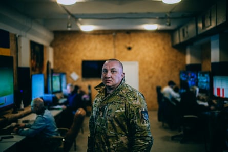 Hersak in a room lined with desks and screens