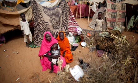 Women and their children sit in a camp in North Darfur. Many of the hundreds deported from Jordan had fled the region.