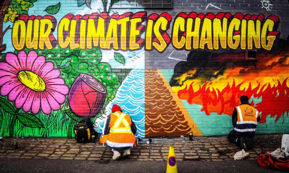 Street artists paint a mural opposite the Cop26 climate summit venue in Glasgow, 13 October.