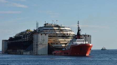The wreckage of the Costa Concordia cruise ship is towed off Giglio Island after it was refloated using air tanks attached to its sides, July 2014.