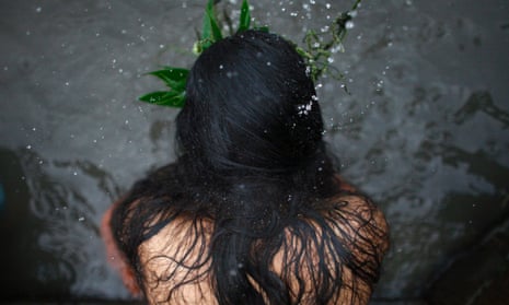 A woman lashes herself with leaves along the banks of the Bagmati river in Kathmandu