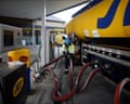Closeup of a black nozzle at a diesel pump at a petrol station in London, with green petrol nozzles behind it.
