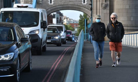 Pedestrians pass heavy traffic on Tower Bridge in London