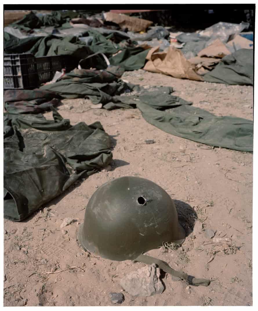 An abandoned helmet with a bullet hole lays on the ground. The last photo taken by conflict photographer/journalist Tim Hetherington