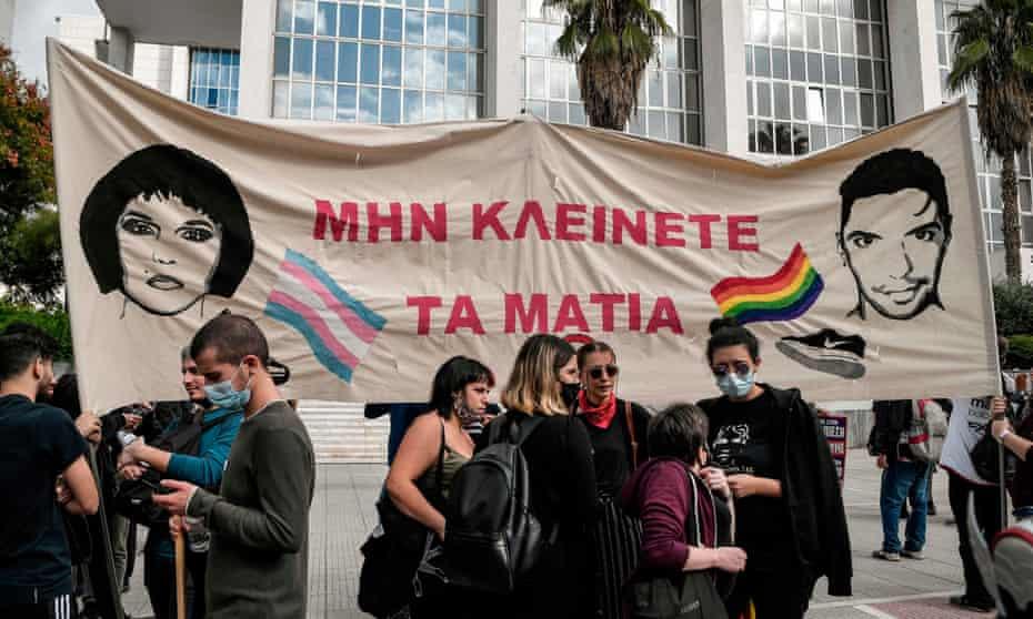 Protesters hold a banner reading ‘Don’t close your eyes’ and bearing the image of Zak Kostopoulos and his alter ego Zackie Oh outside an Athens court.