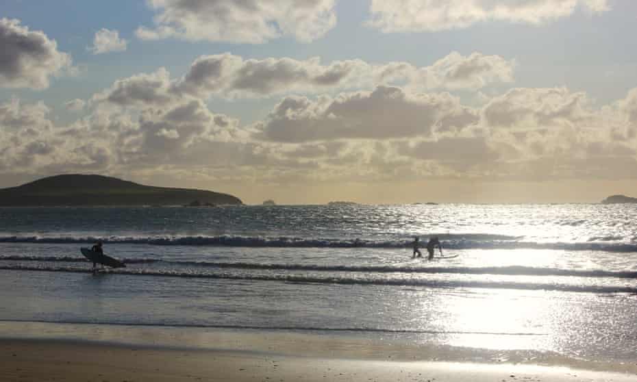 whitesands Charlottebay con sol y surfistas