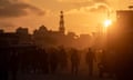 Palestinians walk at sunset in a destroyed street in Khan Younis, southern Gaza Strip. Follow live updates in the Israel-Gaza war.