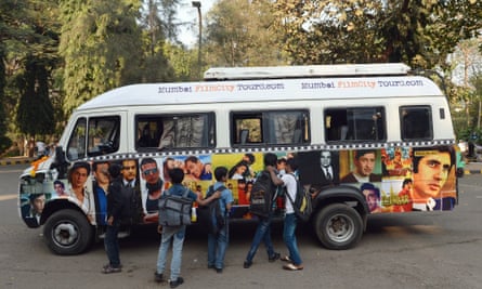 Schoolchildren touch photographs of Indian filmstars adorning a tour van inside Film City in Mumbai, India